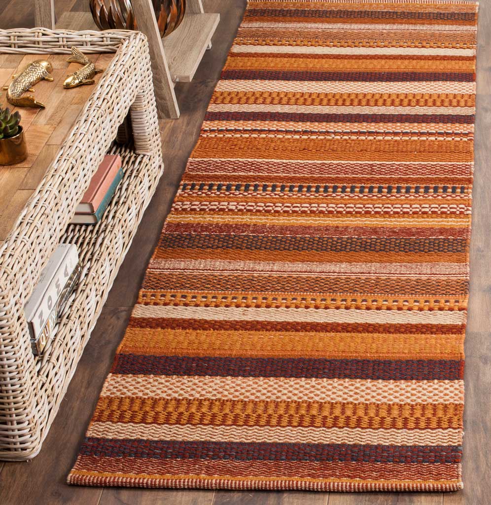 Warm rust and amber stripes give this textured wool runner a cozy accent beside wicker furnishings