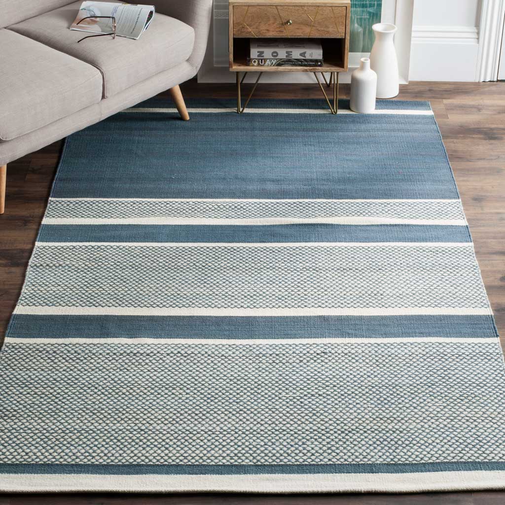 Blue and ivory stripes give this low-profile rug a relaxed look beside a sofa and wood furnishings.