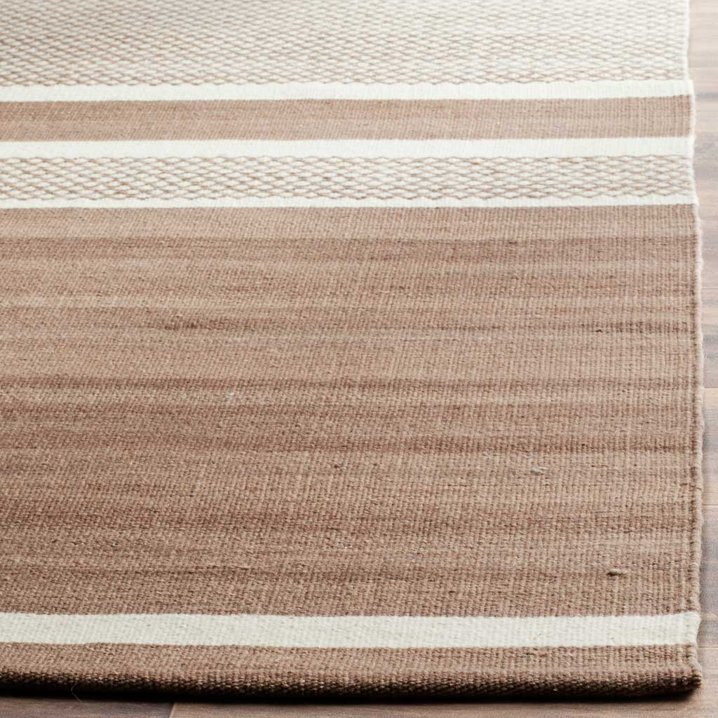 Subtle brown striations meet slim ivory bands along the rug's neatly finished edge.