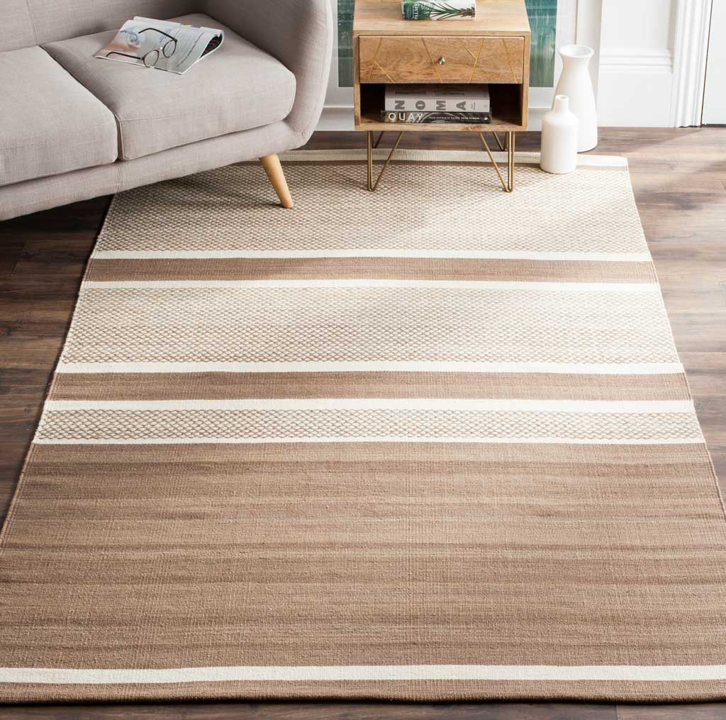 Brown and ivory striped rug adds soft woven texture beneath a sofa and wood furnishings.