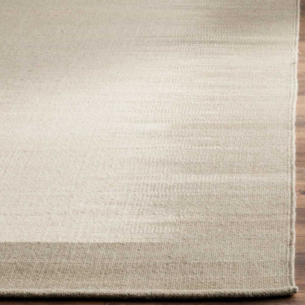 Muted green border frames a finely striated beige wool surface with neatly finished edges