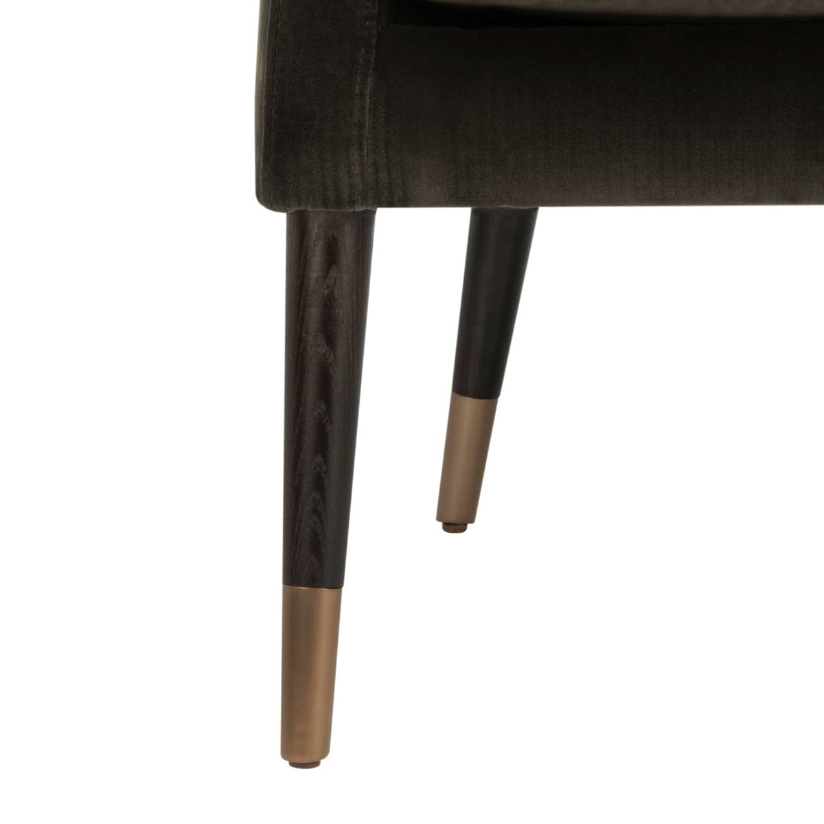 Dark tapered wood legs are finished with warm antique brass caps beneath the velvet seat.