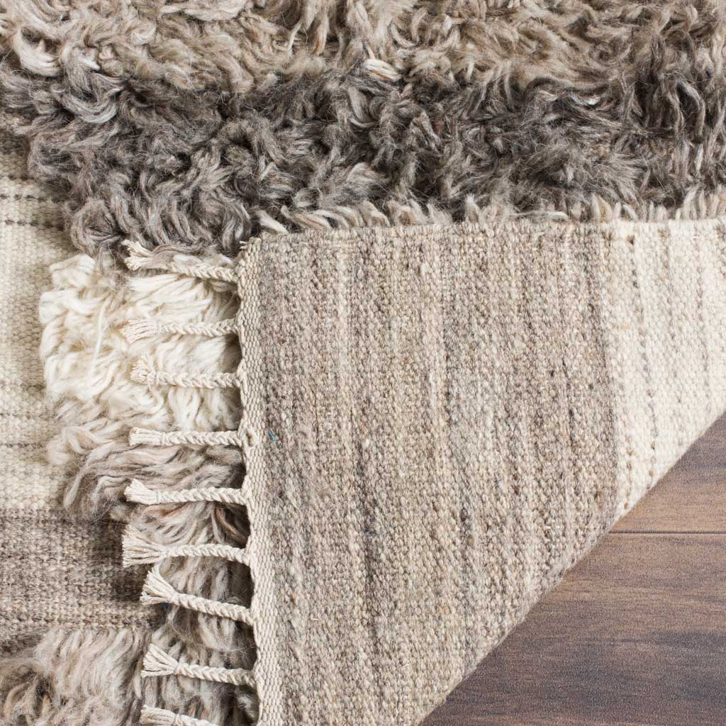 Folded rug corner reveals a woven backing beneath the textured pile