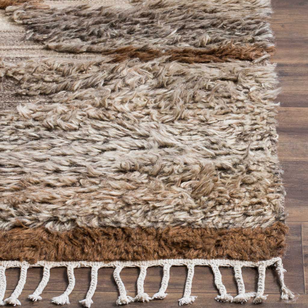 Thick cream and gray fibers meet a rich brown border and knotted fringe.