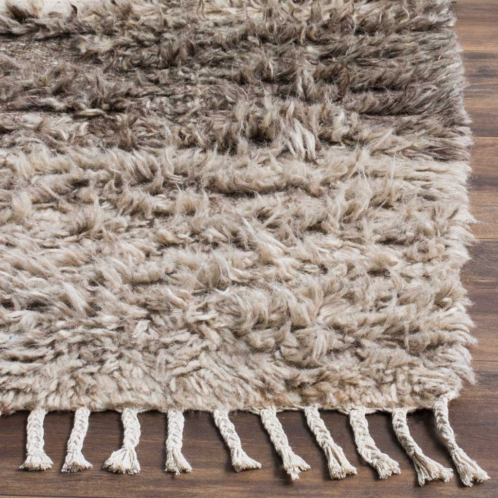 Thick ivory and gray shag pile and knotted fringe bring texture to the rug's edge