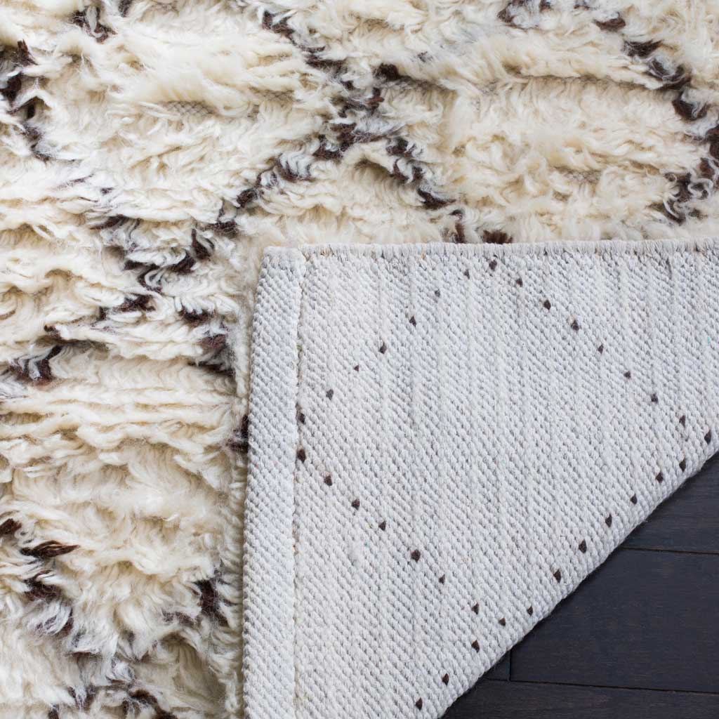 Woven ivory backing supports the rug's plush, brown-flecked pile