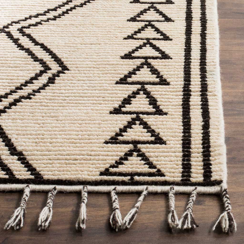 Textured ivory pile sets off black triangle motifs, striped borders, and twisted fringe