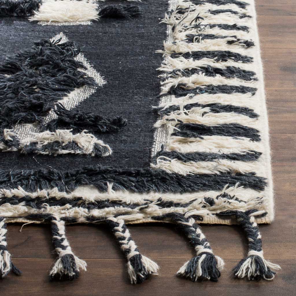 Thick charcoal and ivory yarns form a textured border with braided tassels
