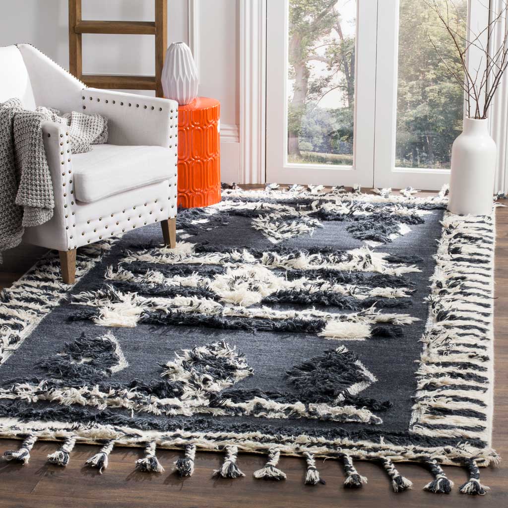 Plush charcoal and ivory rug with raised geometric motifs and fringe anchors a bright seating area