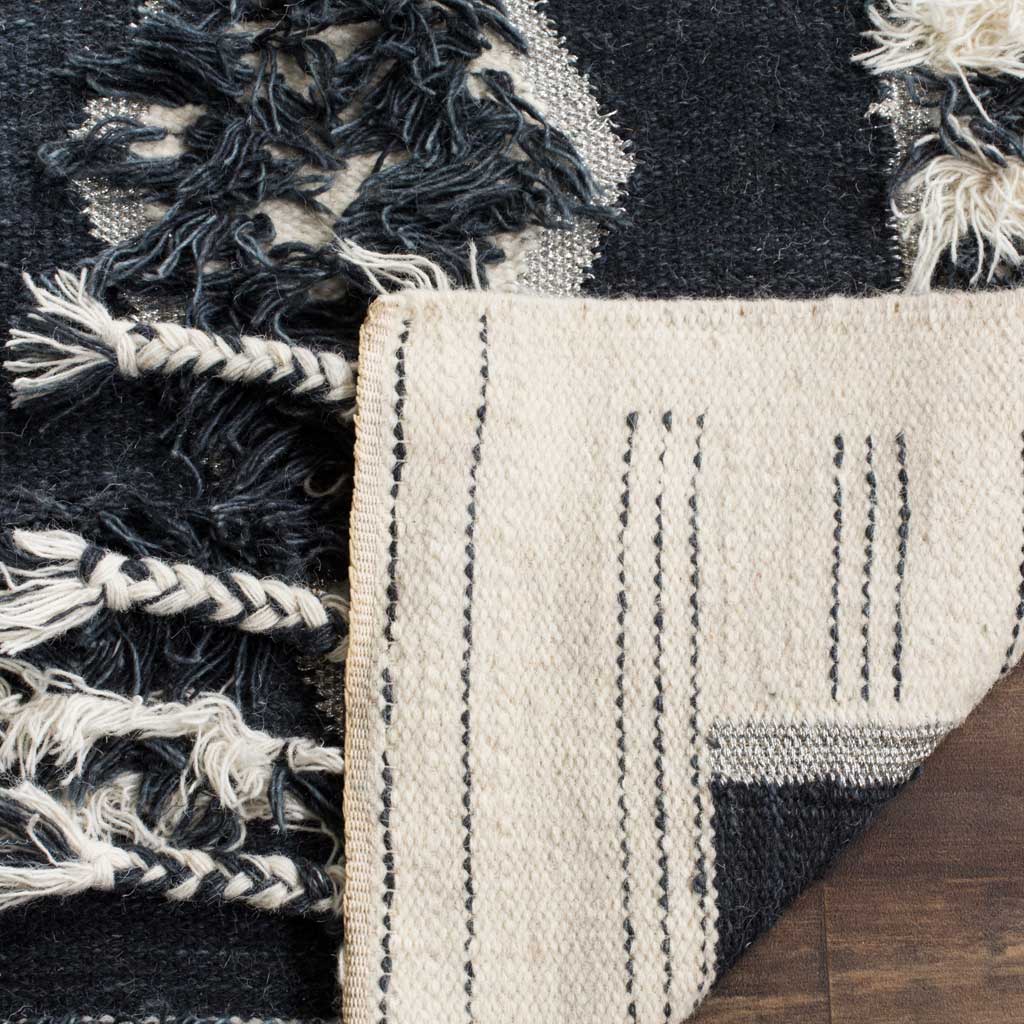 A folded corner reveals the woven ivory underside beneath the charcoal and ivory pile