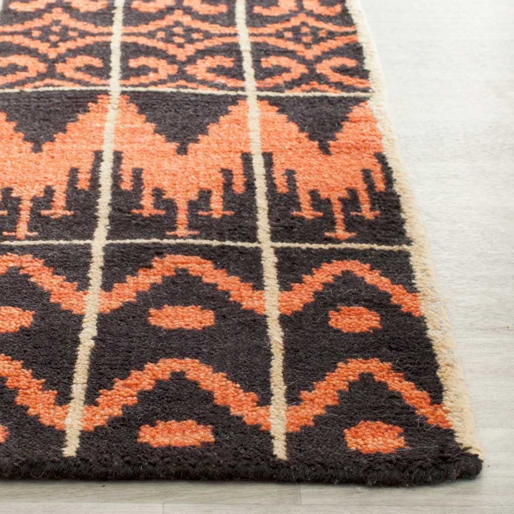 Textured pile and a finished edge frame vivid orange motifs against a black ground