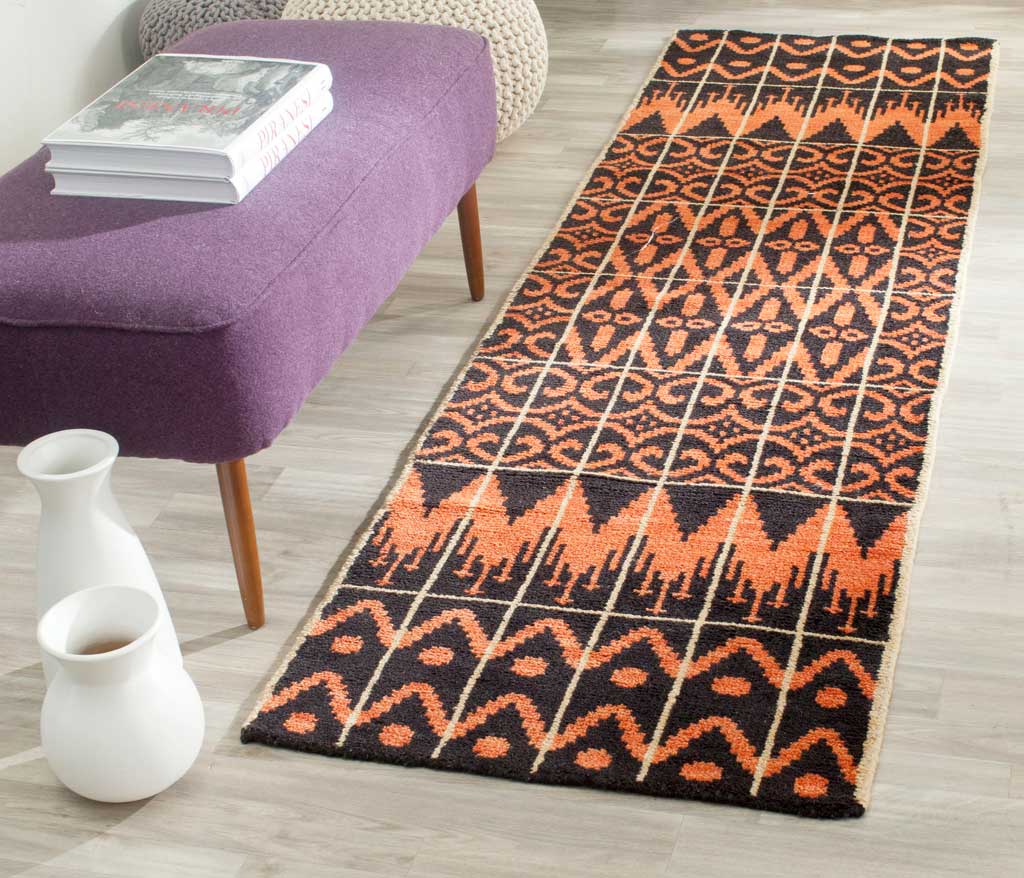 Hand-knotted runner brings warm orange color and bold geometric pattern to a seating area