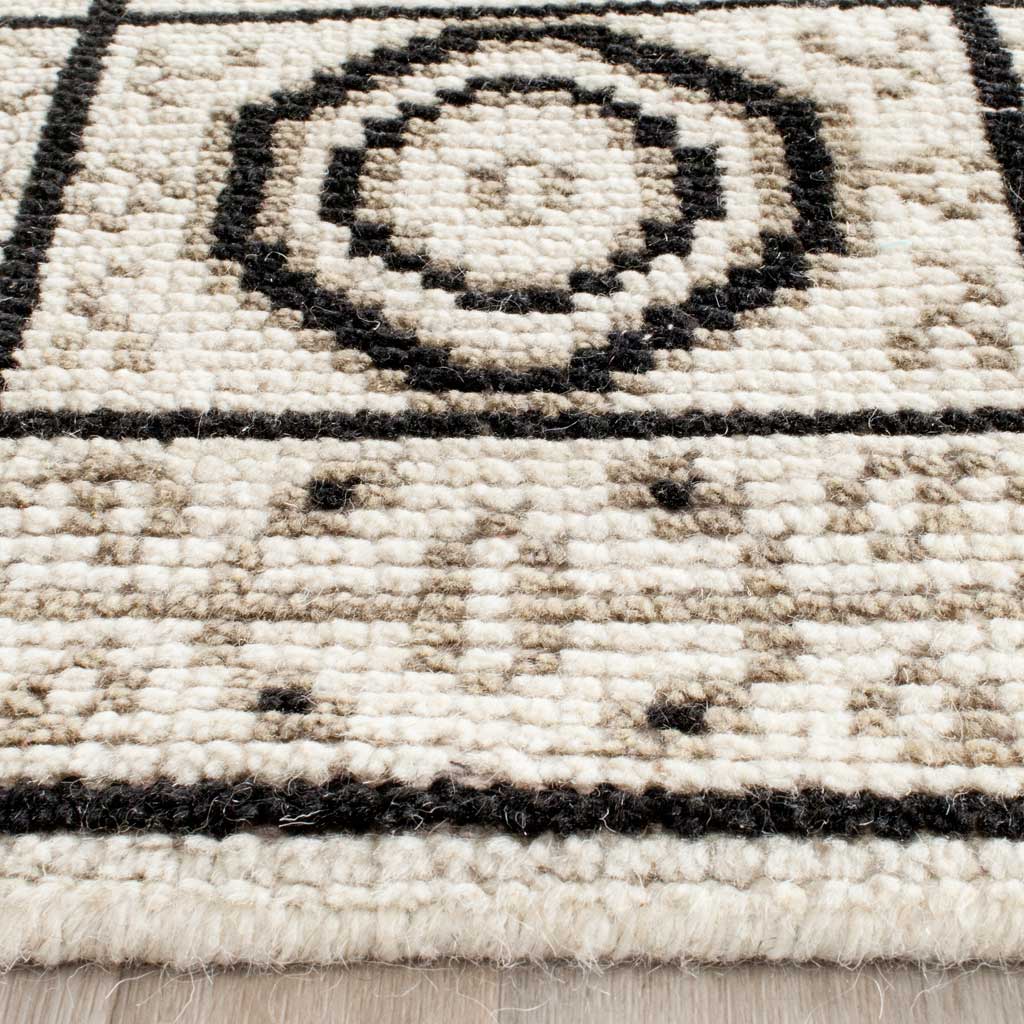 Textured ivory pile features dark geometric lines and a neatly finished edge