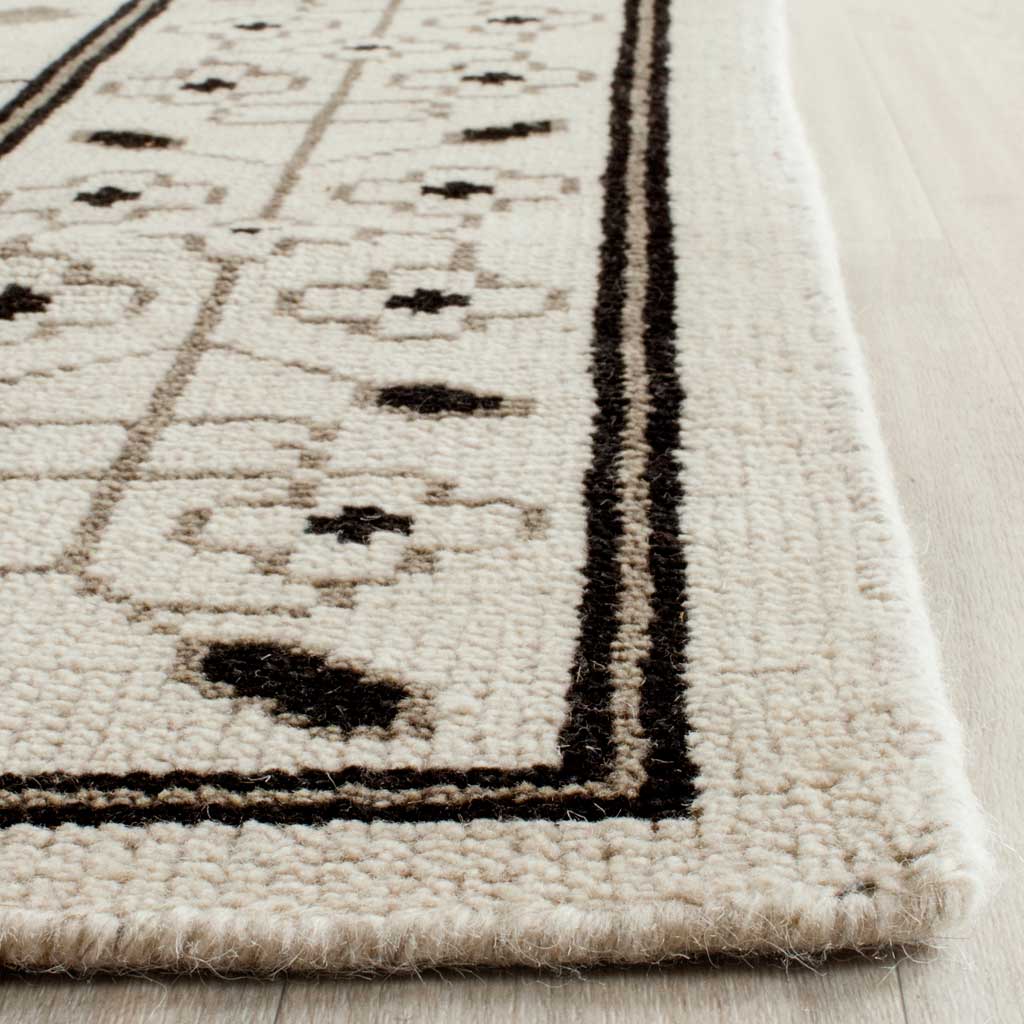 Soft ivory pile and contrasting dark lines meet at a neatly finished rug corner
