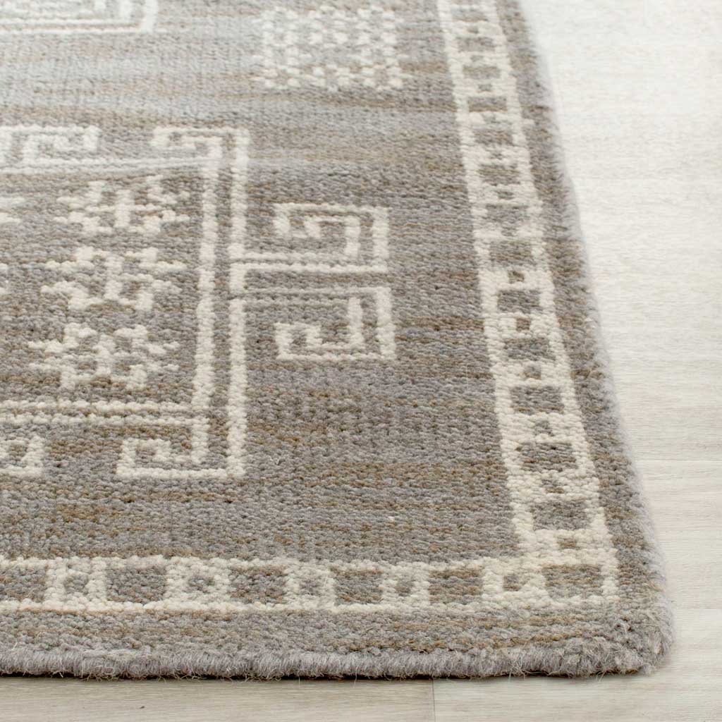 Wool-rich gray pile and a neatly finished edge frame delicate ivory motifs