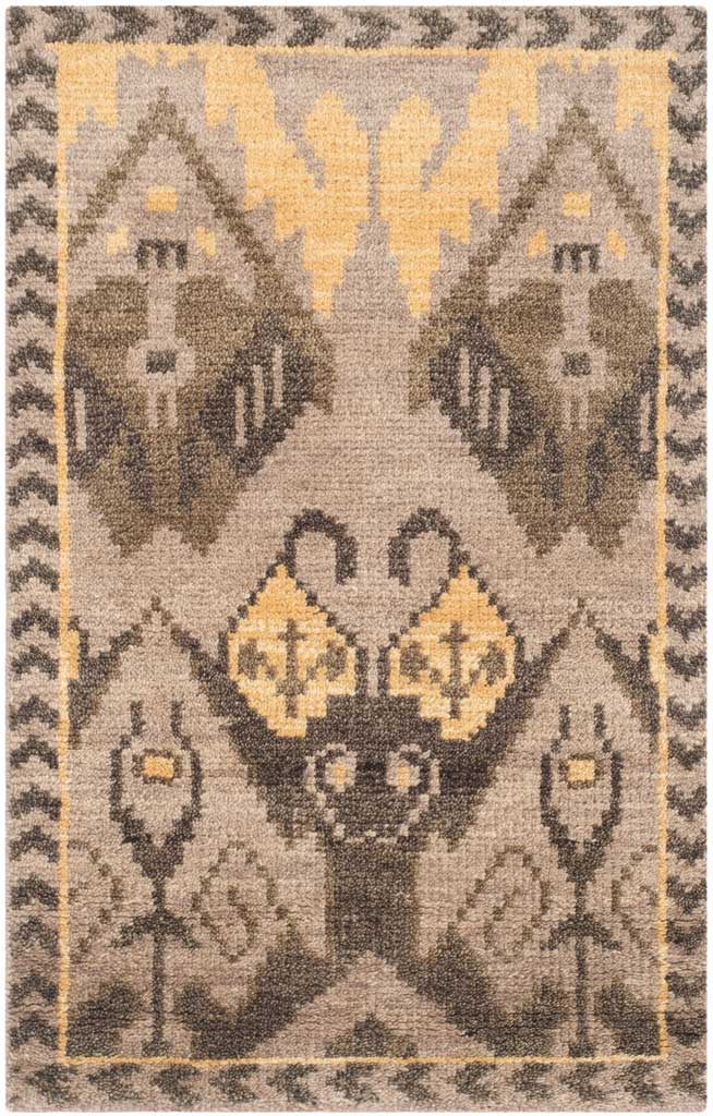 A compact beige rug displays a bold central gold motif framed by dark geometric accents.