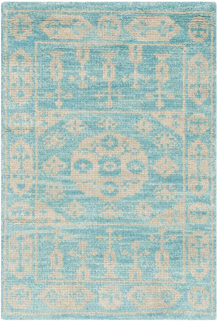 A compact aqua-blue rug pairs a cream medallion with geometric accents and a framed border.