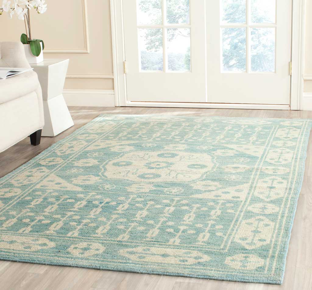 A blue-and-ivory medallion rug lends classic charm and soft color to a bright living space.
