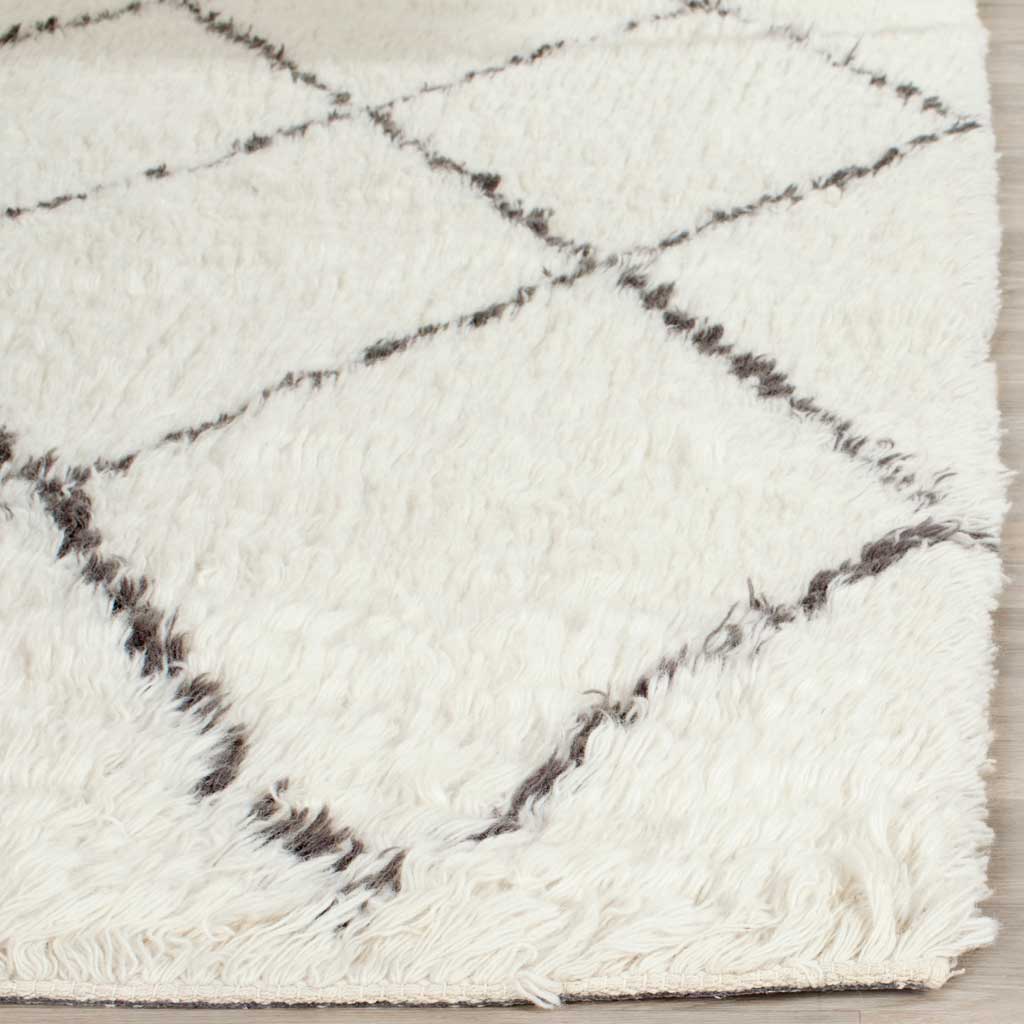 Long ivory fibers and charcoal-gray diamonds create plush texture along the rug's edge
