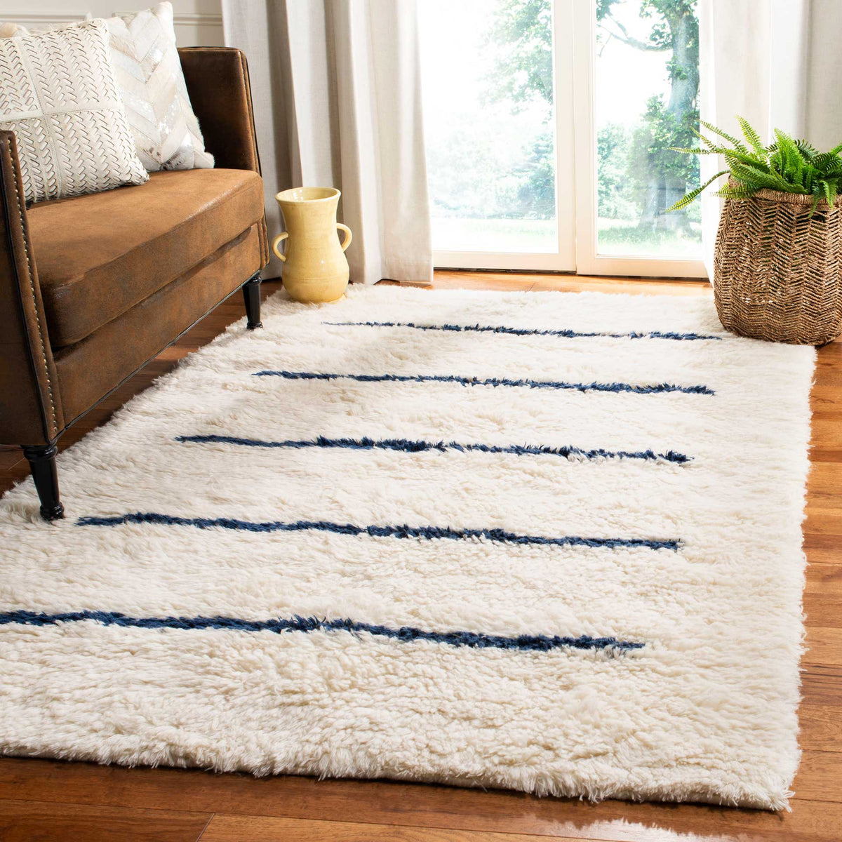 A plush ivory rug with navy stripes adds quiet contrast to a wood-floored living space.
