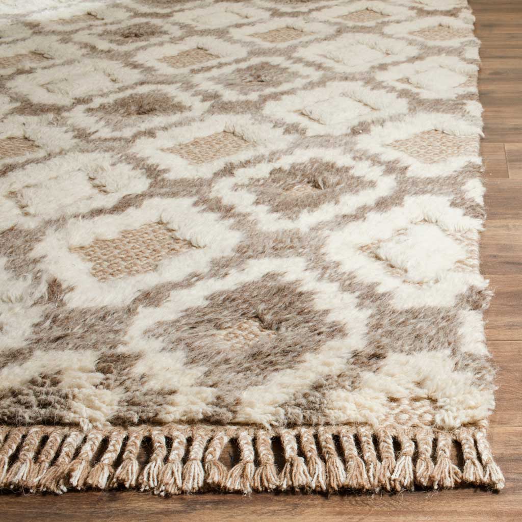 Shaggy cream pile and woven tan motifs meet a row of thick, knotted fringe