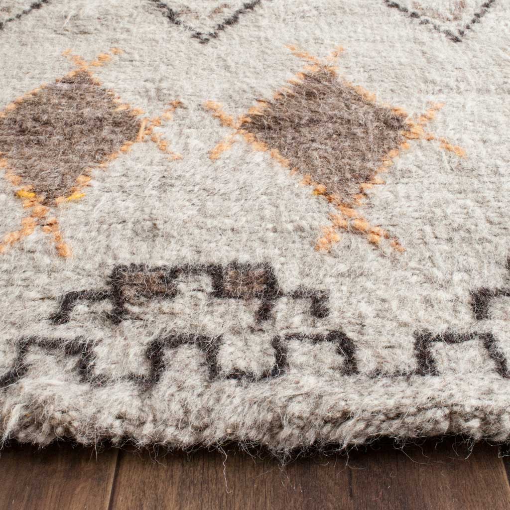 Thick wool-blend pile reveals warm brown diamonds, orange accents and a textured geometric edge.