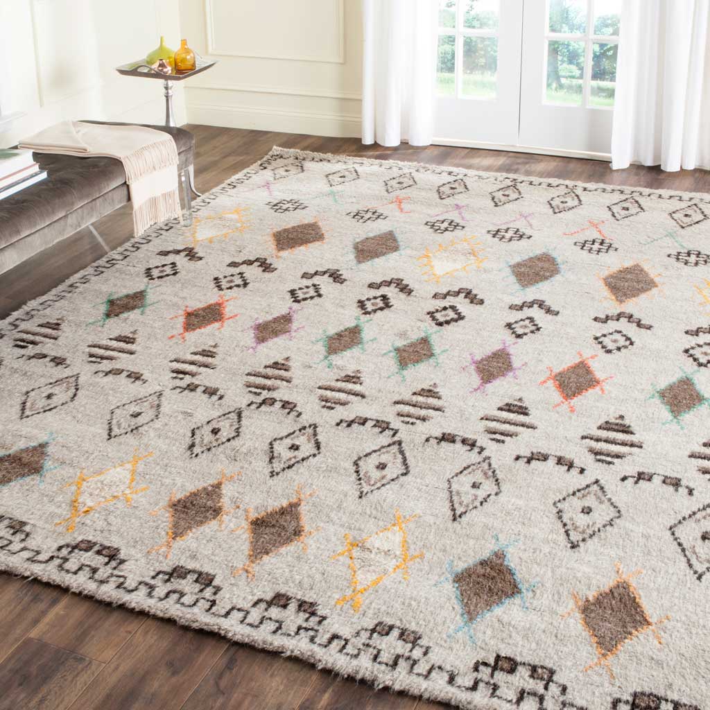 Colorful geometric diamonds brighten this plush natural rug, framed by a dark patterned border.