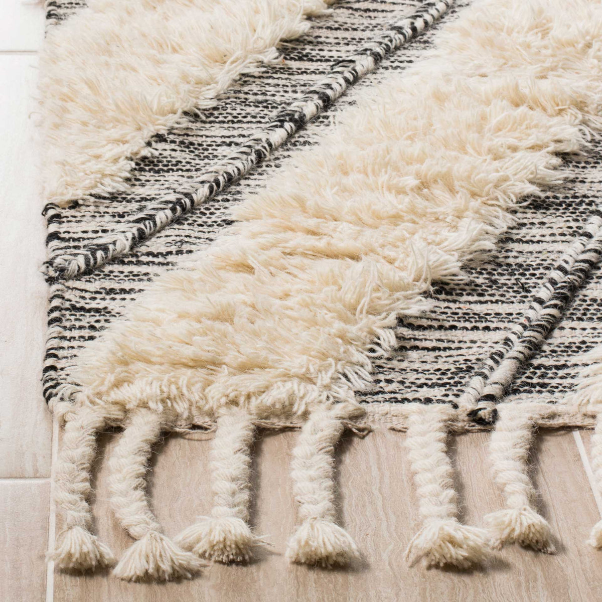 Raised ivory tufts contrast with black woven stripes and chunky fringe