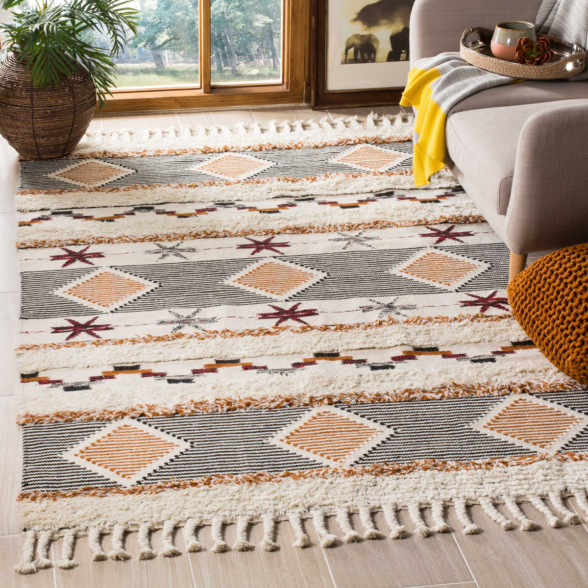 Fringed ivory rug brings graphic black stripes and warm orange diamonds to a cozy living room