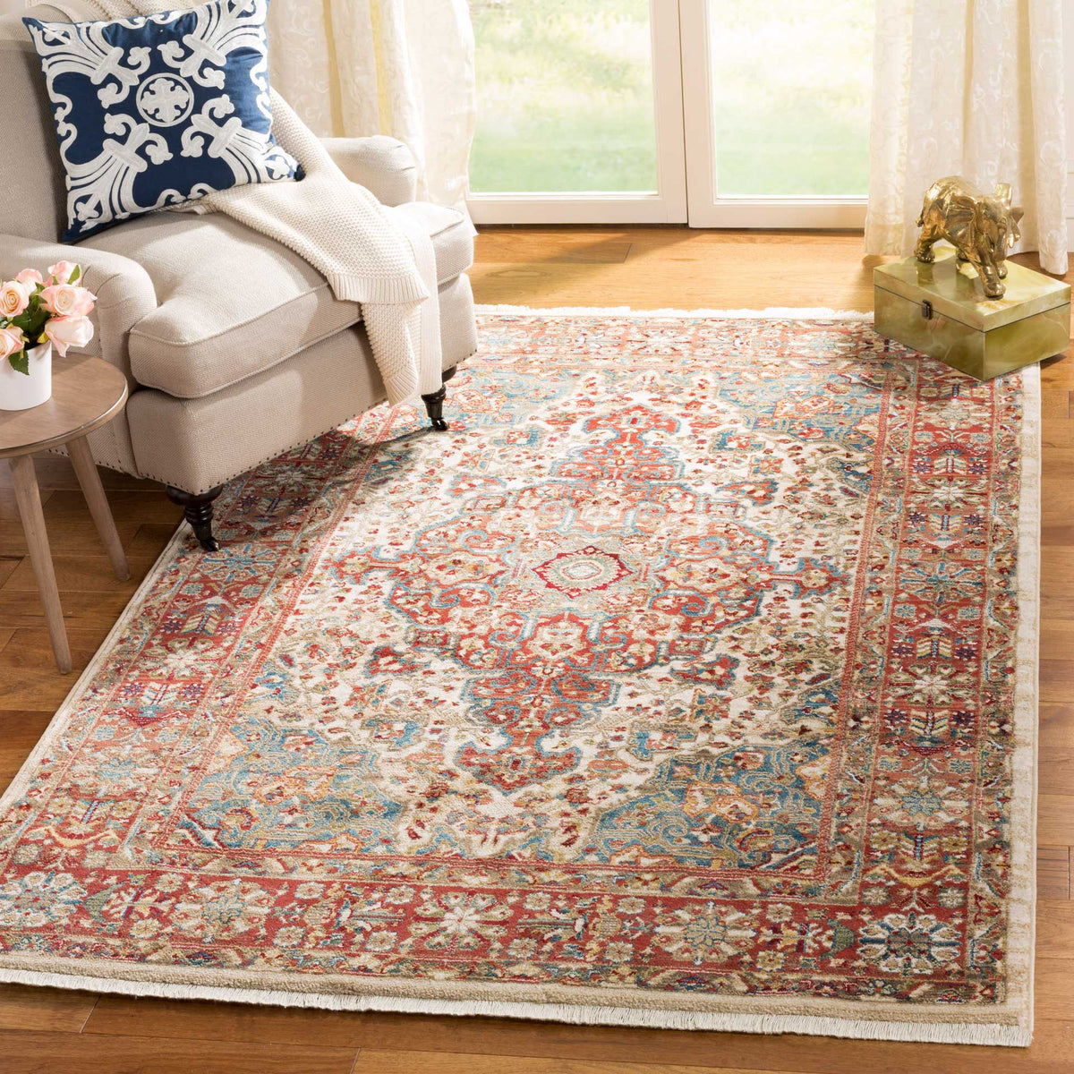Intricate red and blue florals brighten the ivory rug, framed by a warm patterned border