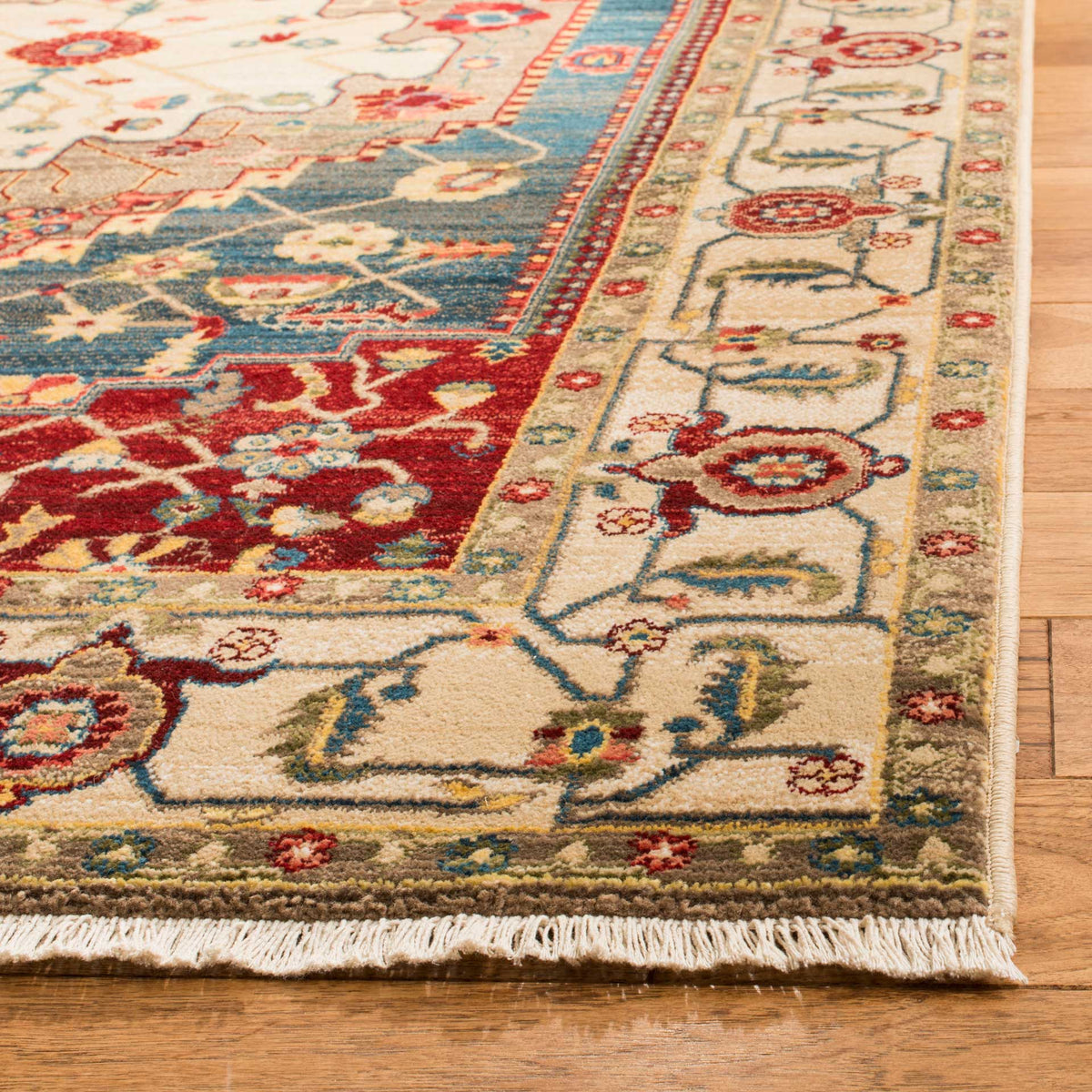 An ivory floral border, colorful accents and short fringe finish the textured rug