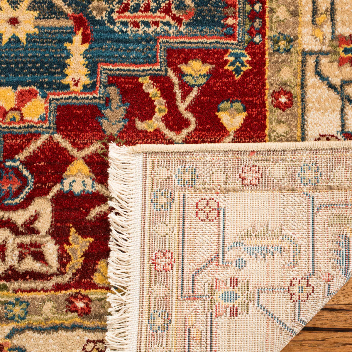 A folded edge reveals woven backing beside ivory fringe and richly patterned pile
