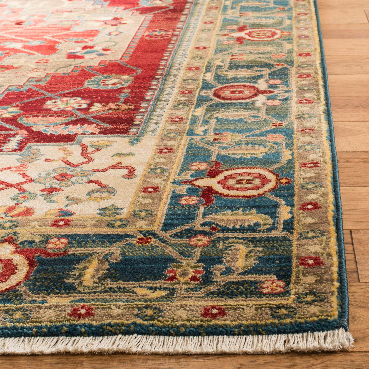 A blue floral border, golden accents and pale fringe finish the rug's detailed edge