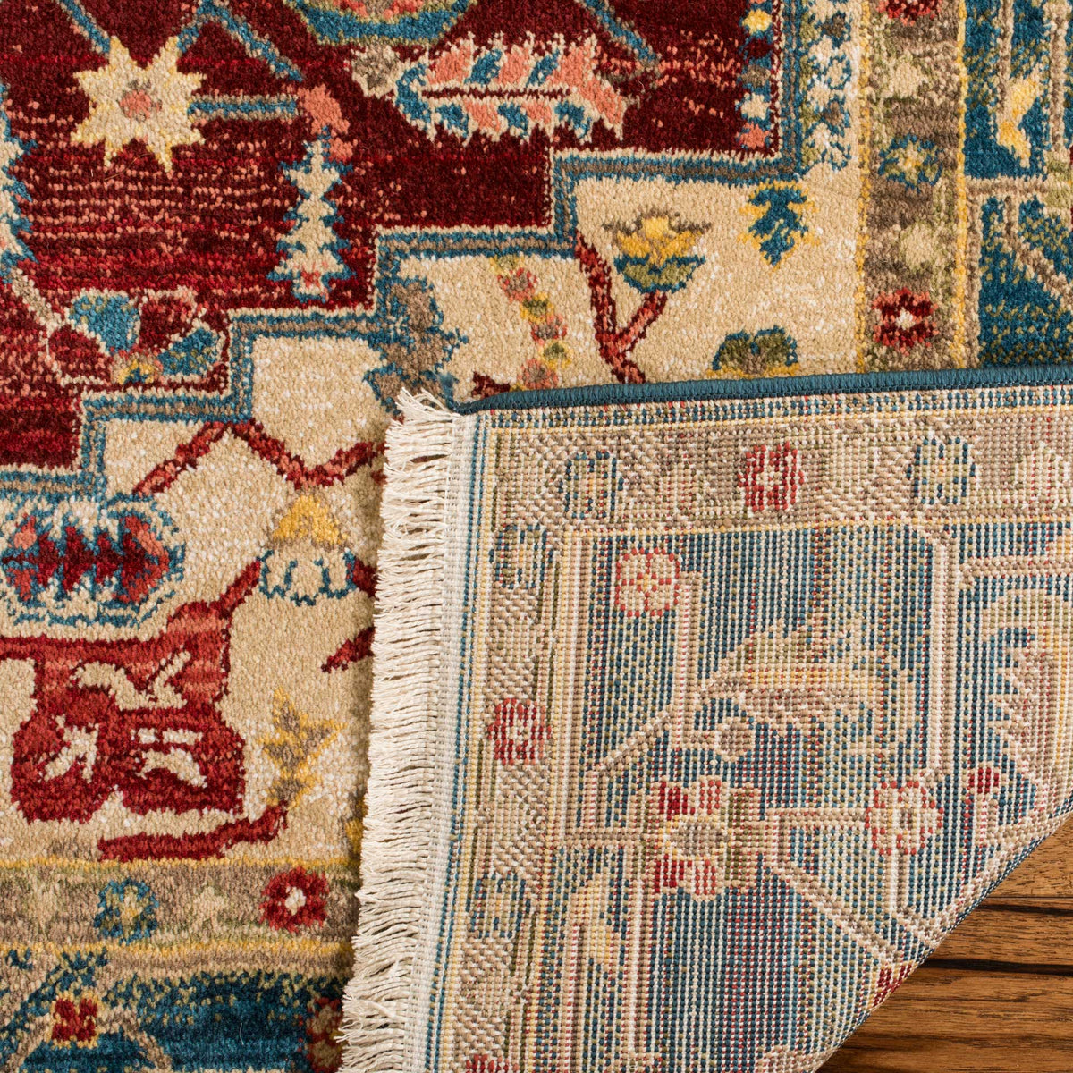 A turned-back corner exposes woven backing beneath the colorful floral pile