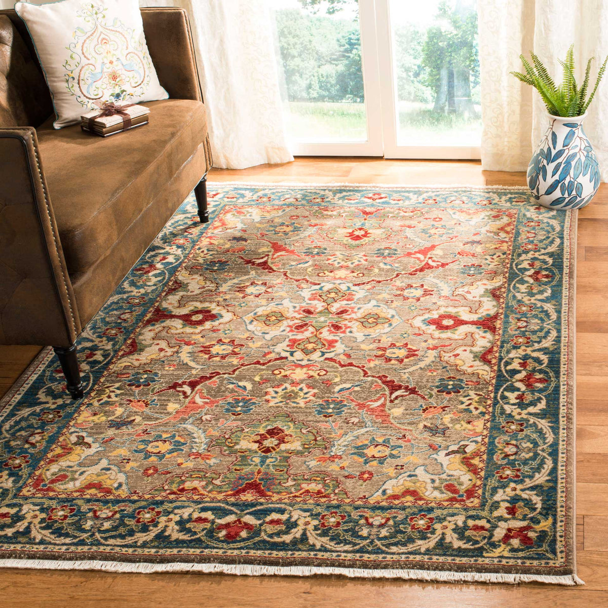 A taupe and blue rug adds layered florals and a richly patterned border to the living room.