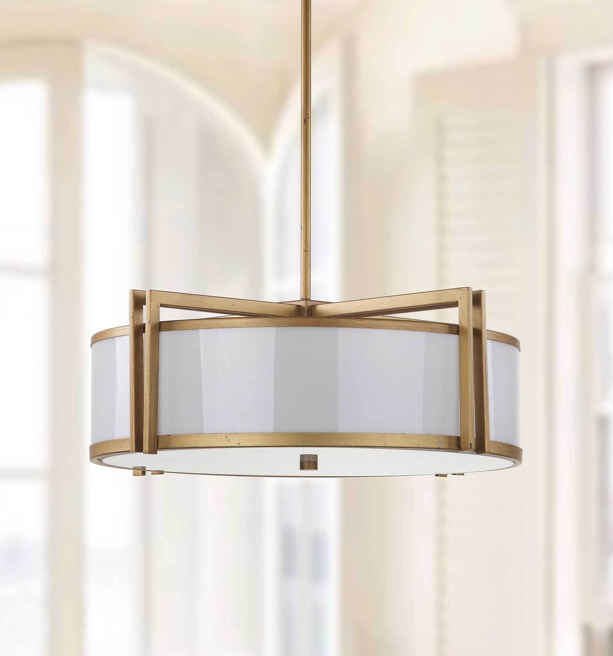 A pale drum shade and graceful antique gold trim bring understated elegance to an airy interior