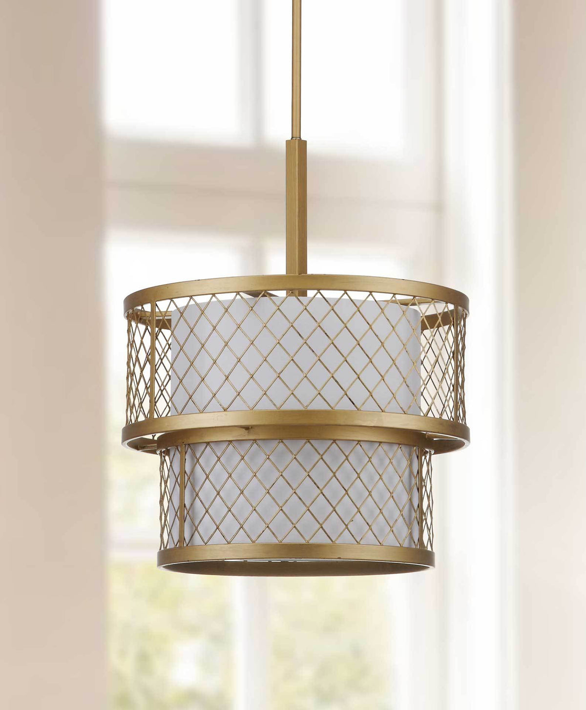 Two off-white fabric tiers soften the pendant's sculptural gold mesh frame