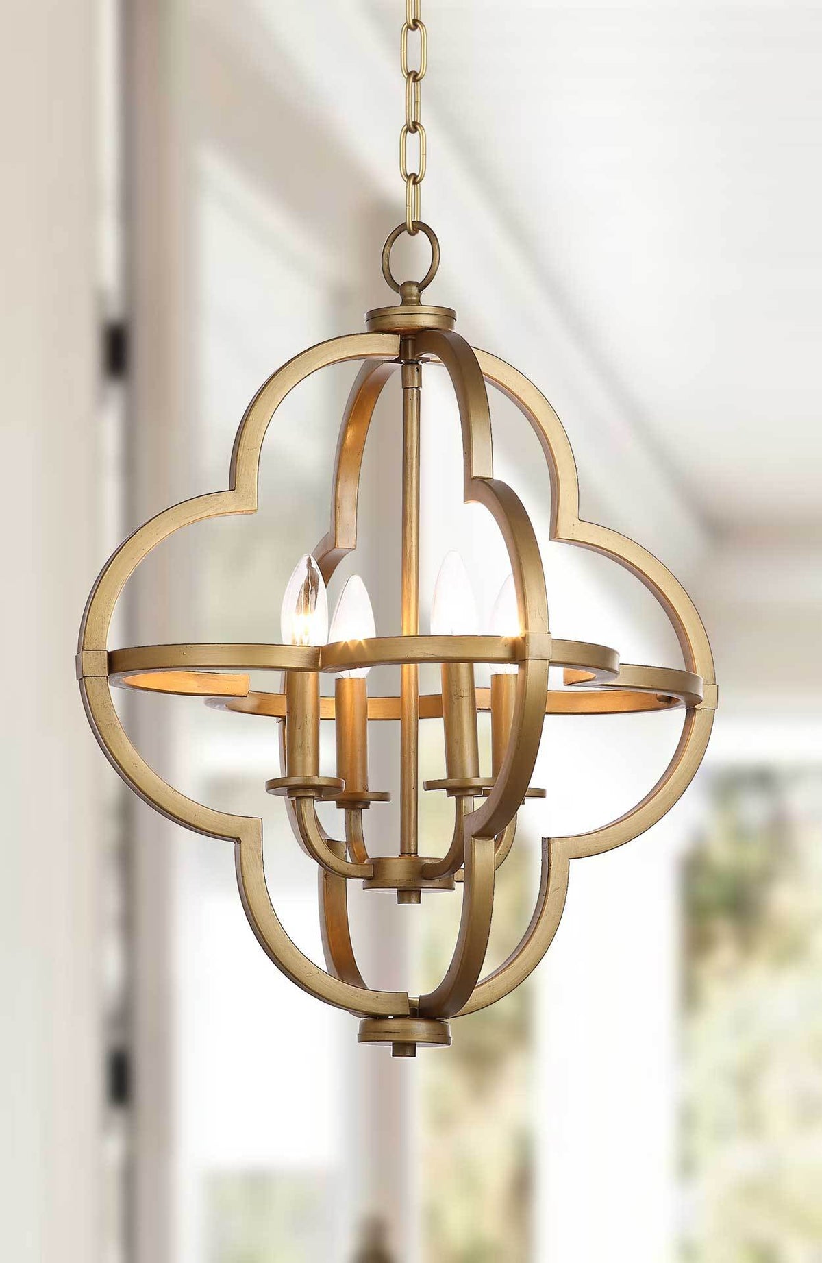 Glowing candle bulbs illuminate the open quatrefoil silhouette of this brass-tone pendant