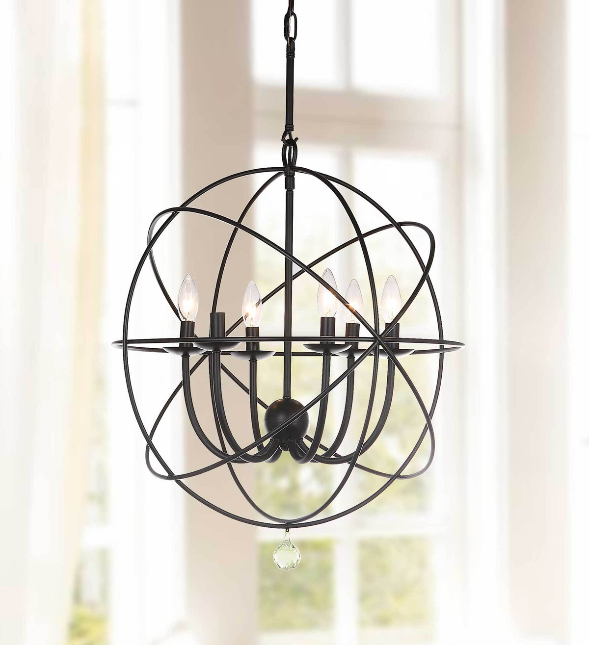 Glowing candle bulbs brighten the sculptural black iron frame and faceted drop accent