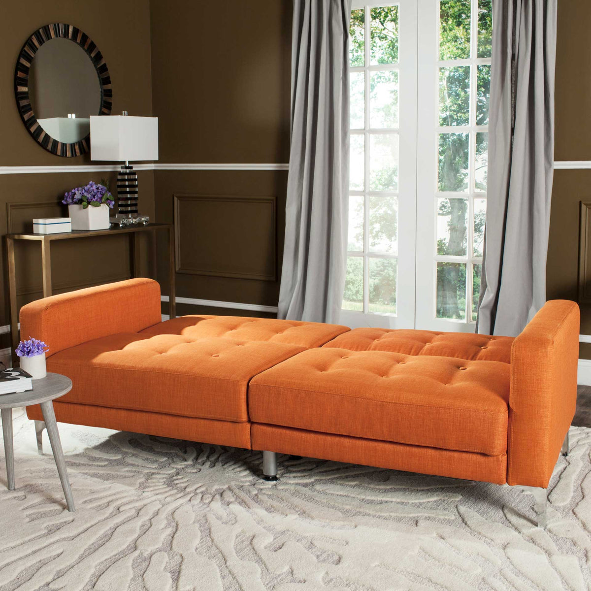 Orange cushions unfold into a roomy bed framed by low, upholstered arms.