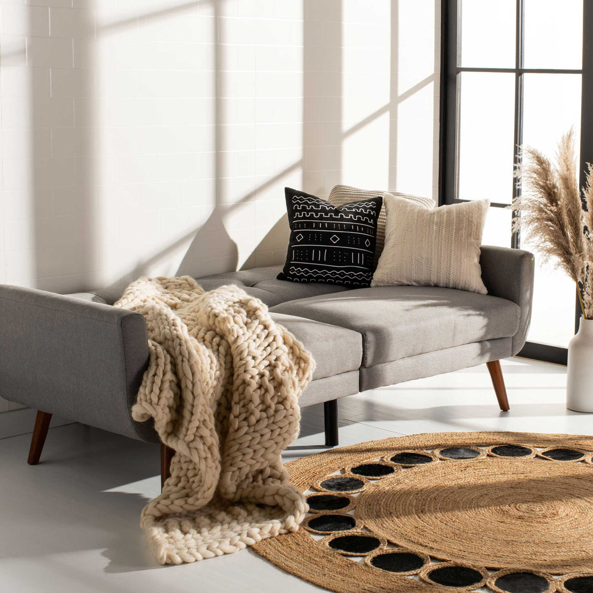 Light gray upholstery forms a broad sleeping surface with a button-tufted cushion section.