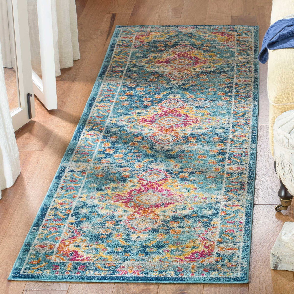 Teal and fuchsia runner rug brings vintage-inspired pattern to a wood-floored space.
