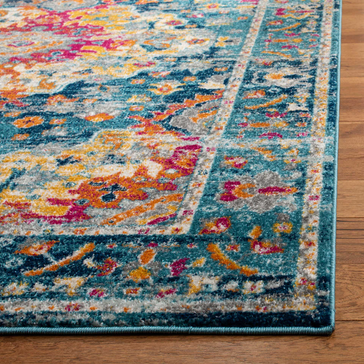 A neatly bound teal edge complements the textured floral pattern in fuchsia, gold, and orange