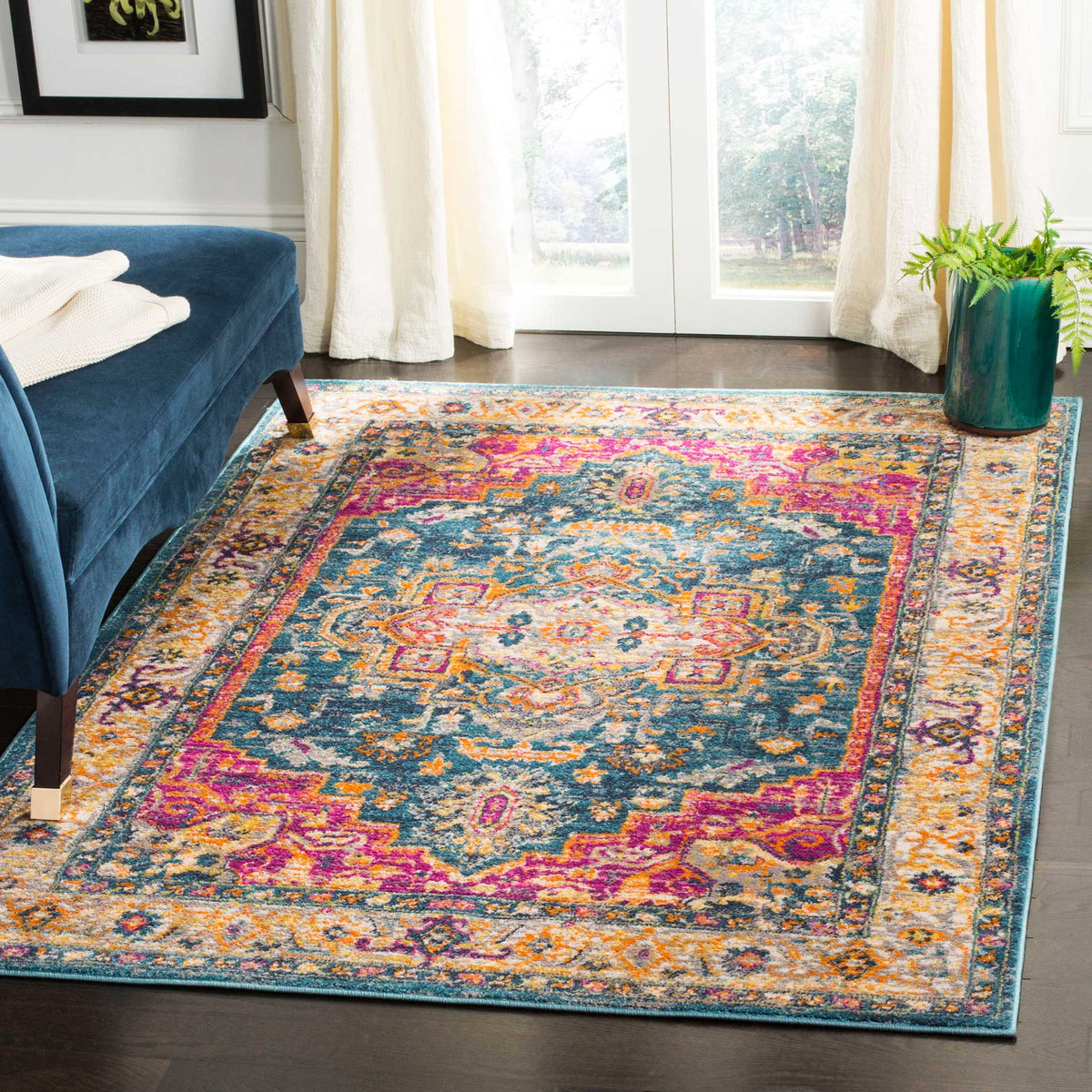 A patterned blue rug anchors a living space with pink, orange, and ivory medallion motifs