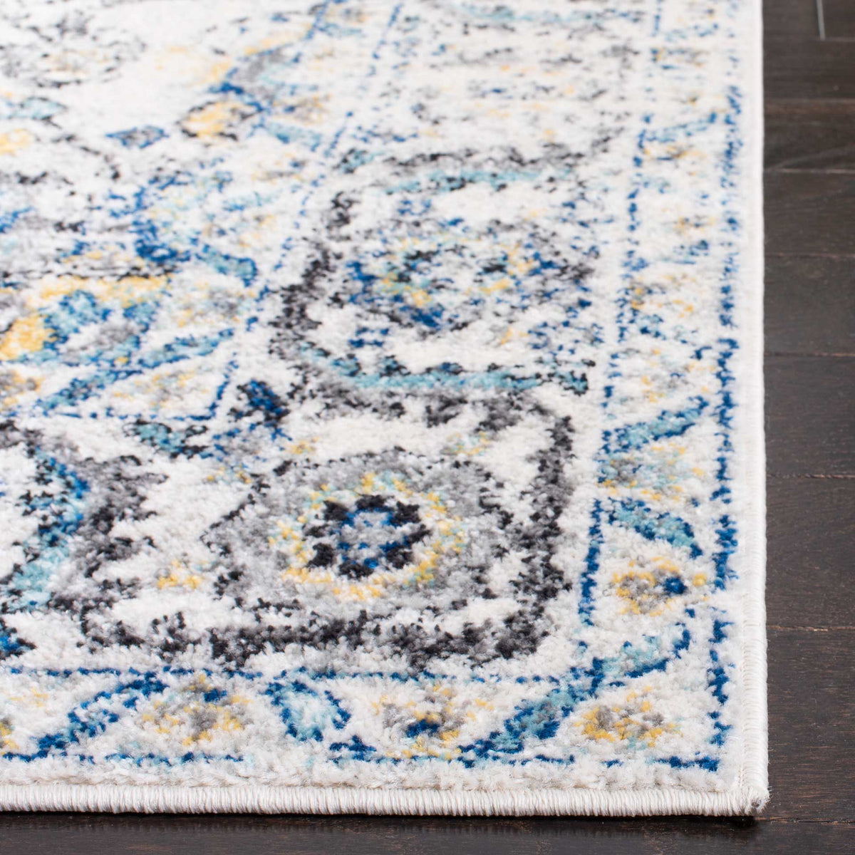 Blue and gold flourishes brighten the gray and ivory rug's floral border and bound corner