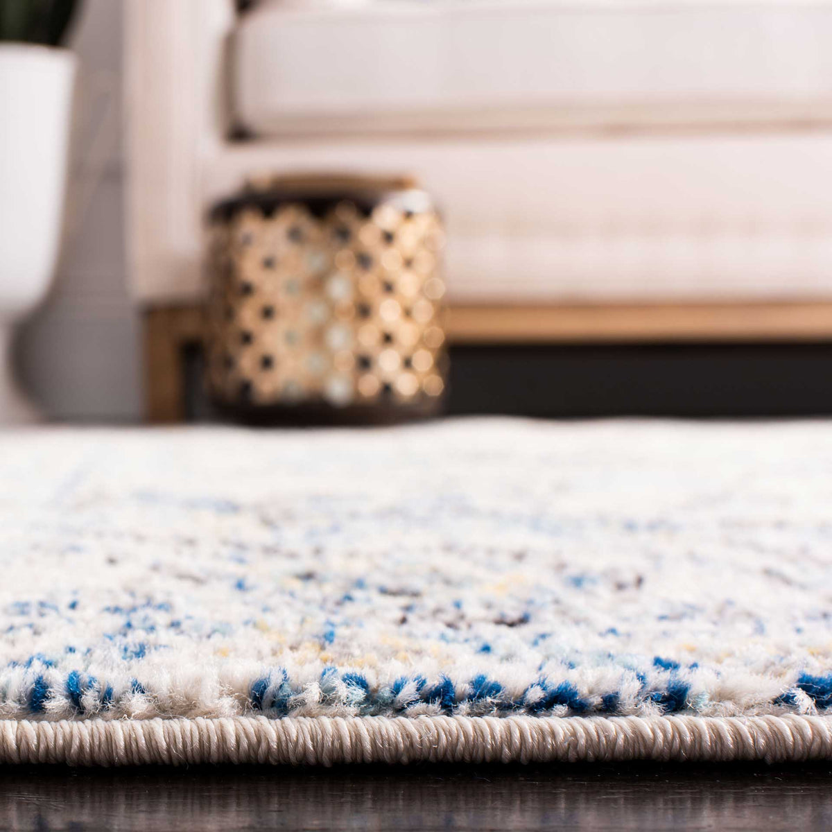 Soft ivory pile with blue and gray accents meets a tightly bound edge