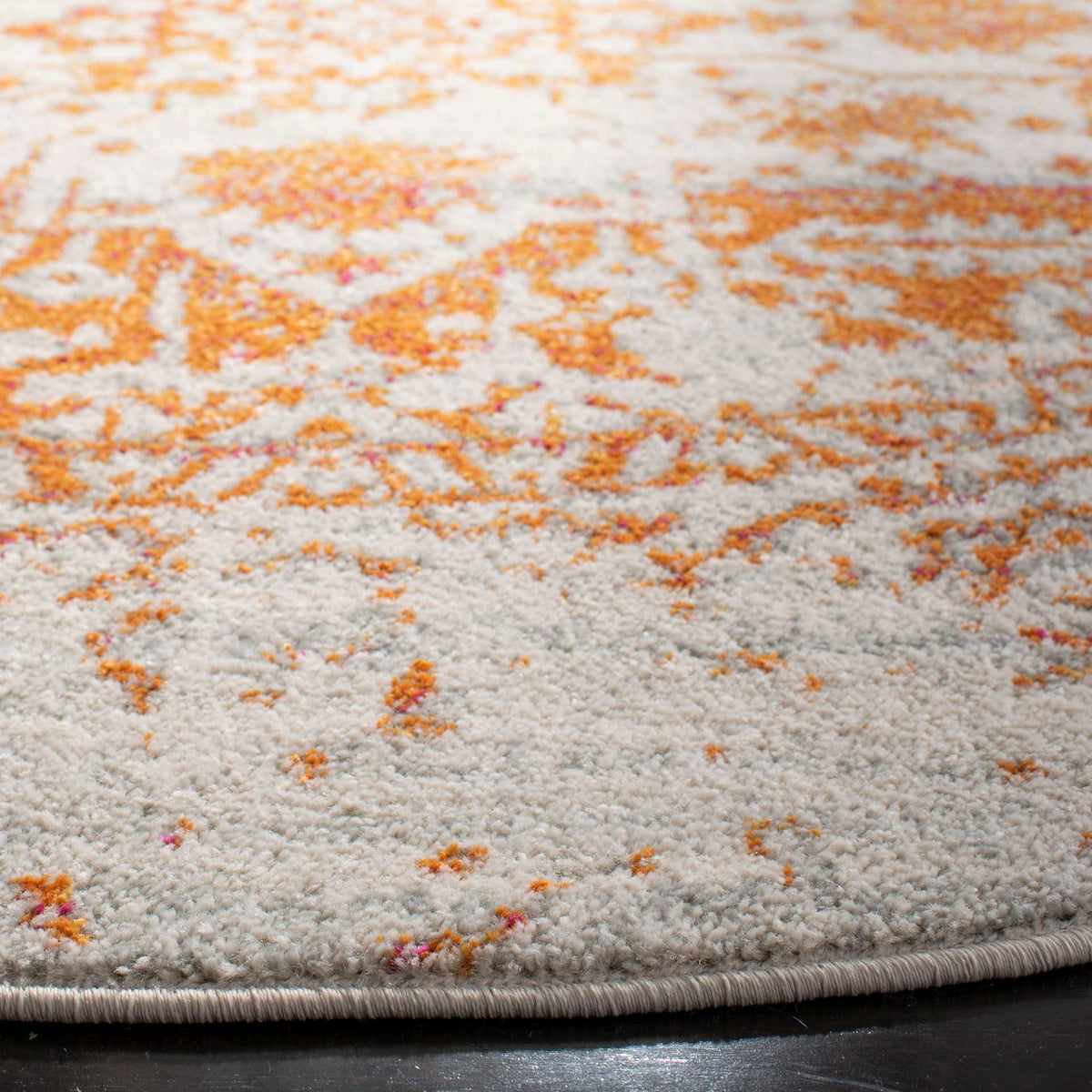 A neatly bound edge frames the ivory pile and vivid orange motifs
