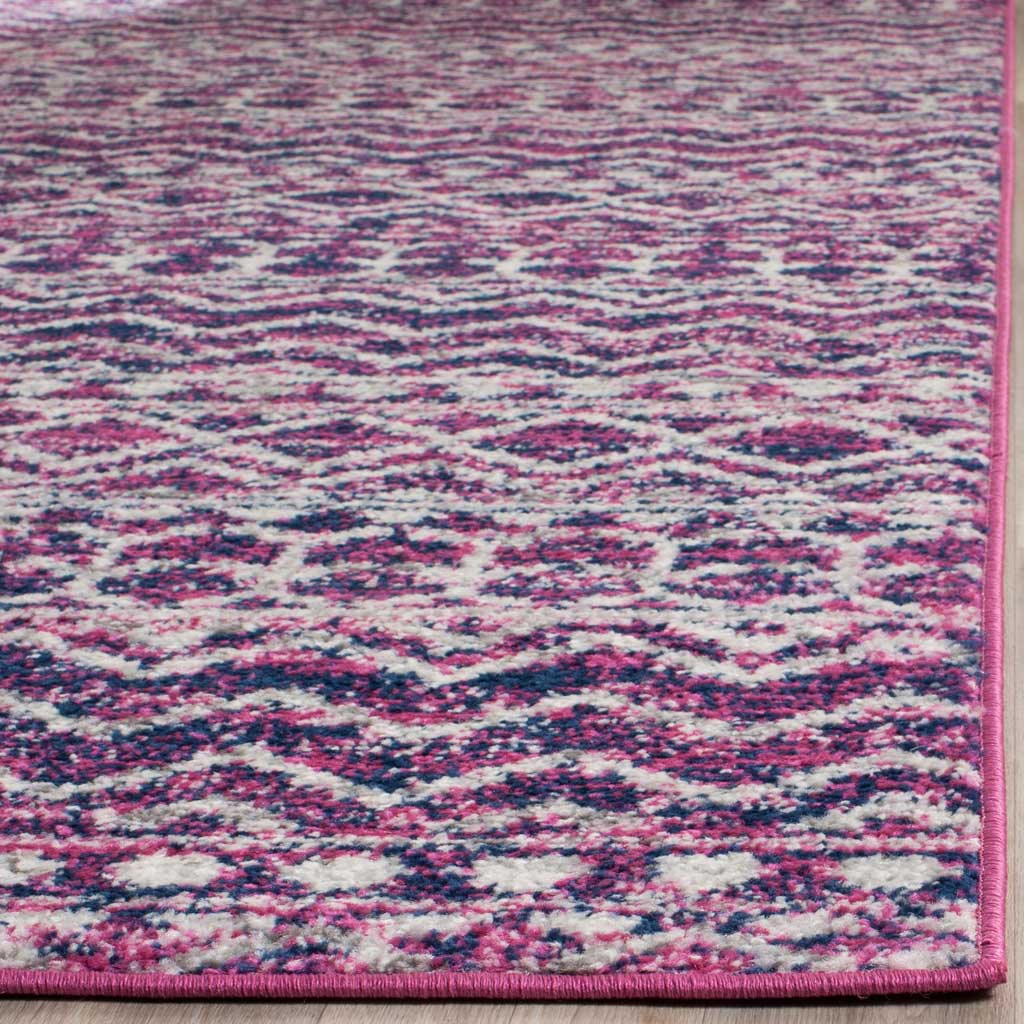 Dense fuchsia and navy motifs meet a neatly bound pink rug edge