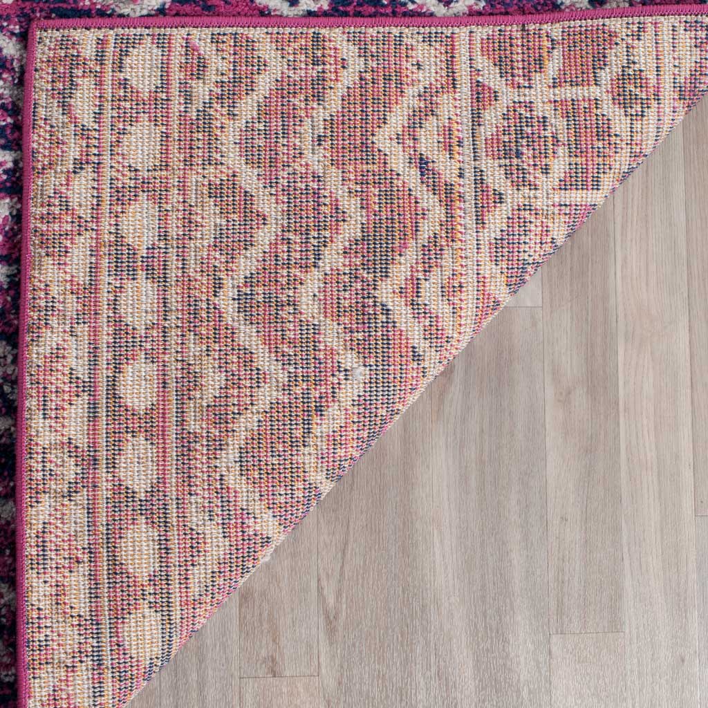 A turned rug corner reveals its patterned backing and neat pink binding