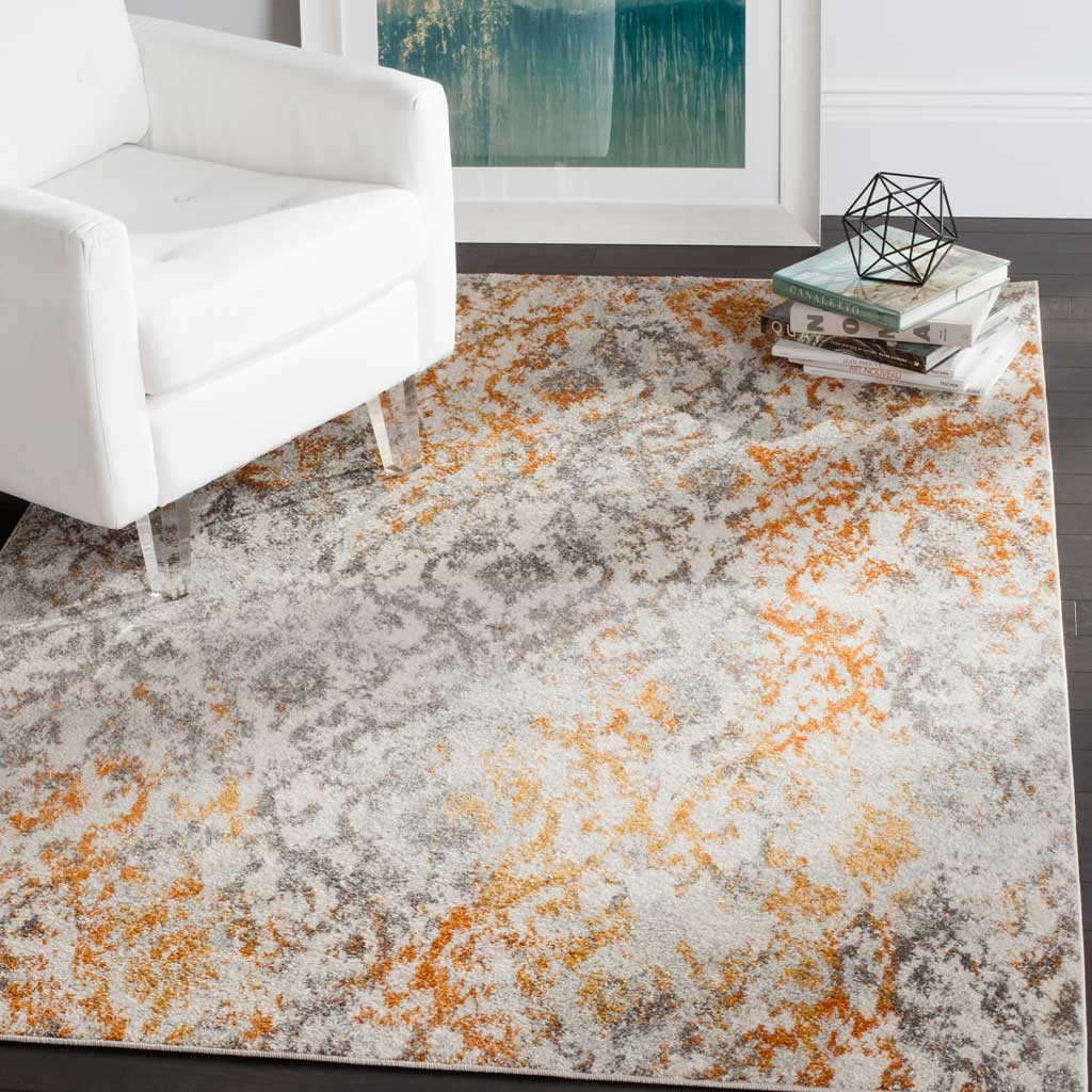 Cream rug with distressed orange and gray motifs adds warmth beside a white chair